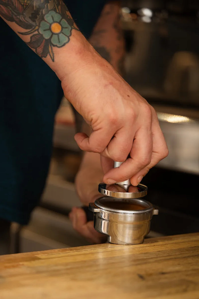Geste barista : tassage du café dans le porte-filtre